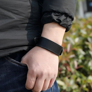 Close-up of black leather bracelet on man's wrist featuring reinforced stitching detail