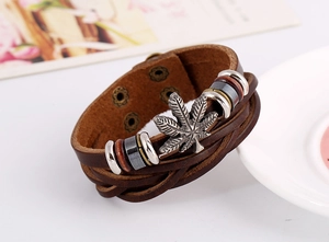 Détail d'un bracelet en cuir multicouche avec breloque feuille d'érable et perles magnétiques