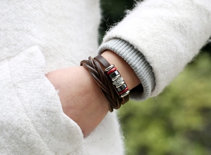 Detail of dark brown multilayer leather bracelet with silver beads and red accents
