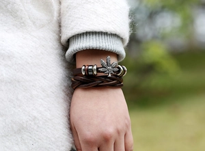 Détail du bracelet multicouche en cuir marron avec breloque feuille pour hommes