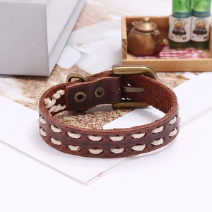 Detail of vintage braided dark brown leather bracelet with bronze buckle and weaving