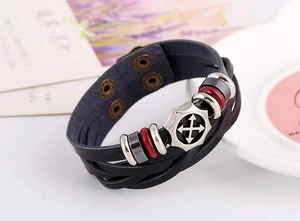 Detail of men's multilayer black leather bracelet with silver alloy badge and red beads