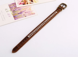Détail d'un bracelet en cuir marron vintage avec coutures blanches et boucle