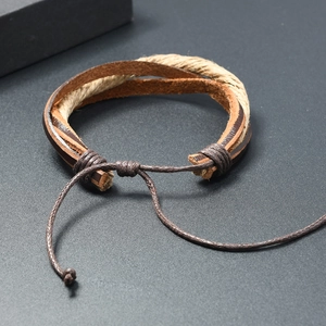 Detail of handmade multi-layer leather bracelet with adjustable braided rope and hemp cord