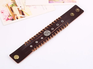 Detail eines braunen Vintage-Lederarmbands mit Gänseblümchen-Metallniete und Webkanten