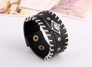 Détail du bracelet manchette punk en cuir noir avec coutures blanches et rivets métal