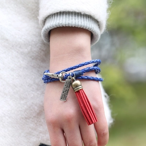 Pulsera de cuero trenzada multicapa hecha a mano con borla roja y dije de bronce vintage