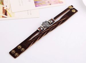 Detail of vintage multilayer brown leather bracelet with silver shield and snap clasp