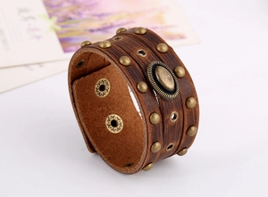 Détail d'un bracelet en cuir punk vintage avec rivets en laiton et médaillon ovale