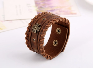 Close-up of vintage brown leather wide cuff bracelet with bronze iron cross rivet