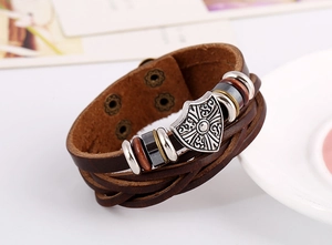 Close-up of brown multilayer leather bracelet with silver shield charm and metal clasp