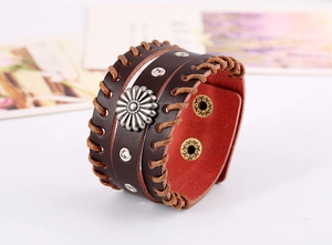 Detail eines Vintage Lederarmbands mit Sonnenblumen-Motiv und dekorativen Metallnieten
