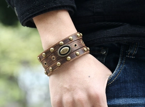 Détail d'un bracelet punk en cuir vintage avec des clous en laiton et un décor métallique