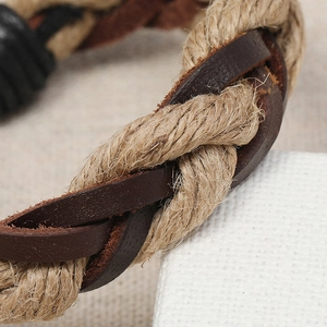 Macro detail of braided hemp rope and dark brown leather texture on retro bracelet