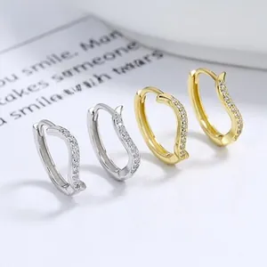 Detail of silver and gold S-shaped earrings with micro-pave cubic zirconia inlay