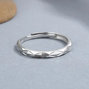 Macro shot of S925 sterling silver ring showing geometric diamond cut texture and inner hallmark