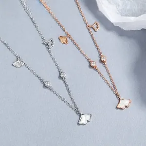 Detail of silver and rose gold ginkgo leaf necklaces with shell inlay and cubic zirconia