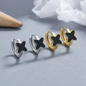Macro shot of clover earrings with black inlay and beaded edges in gold and silver