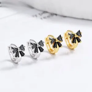 Close-up of silver and gold butterfly ear cuffs with micro-pave black zircon crystals