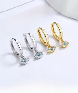 Detailed close-up of 925 silver and gold evil eye hoop earrings with blue stones