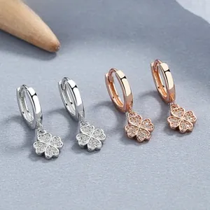Détail des boucles d'oreilles trèfle en argent et or rose avec zircons scintillants