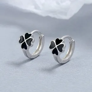 Macro shot of 925 sterling silver hoop earrings featuring black clover-shaped inlay details