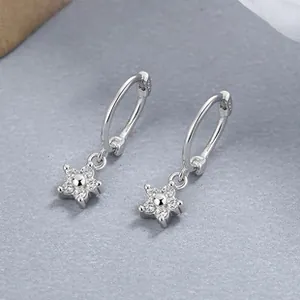Détail macro de boucles d'oreilles étoiles en argent 925 avec zircons bleus incrustés