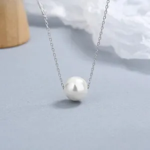 Gros plan d'un pendentif perle blanche lustrée sur une chaîne fine en argent massif