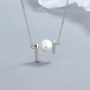 Macro shot of 925 sterling silver necklace with minimalist pearl and metal bars detail
