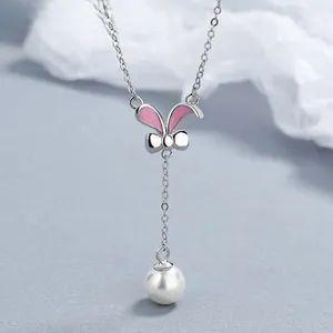 Detailed close-up of rabbit ear pendant with pink enamel and a hanging pearl charm