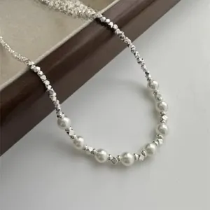 Dettaglio delle perline in argento sterling 925 e perle bianche su una collana minimalista