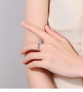 Detailed view of an 925 sterling silver infinity ring with pave stones on finger