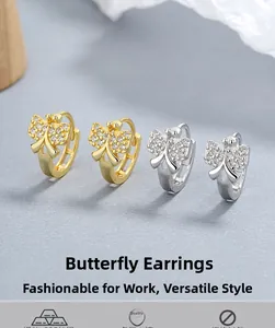 Détail de boucles d'oreilles papillon en argent et or avec zircons étincelants