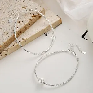 Detail of 925 sterling silver chain bracelets with a white pearl and crushed silver texture