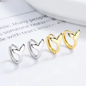 Vue macro de boucles d'oreilles en forme de queue de poisson en argent et or poli