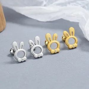 Detailed view of silver and gold rabbit stud earrings with cubic zirconia on matte gray background