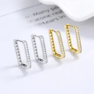 Macro detail of rectangular S925 silver and gold hoop earrings with pavé cubic zirconia