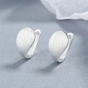Macro detail of 925 sterling silver square earrings with a brushed matte finish surface