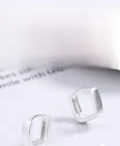 Macro shot of 925 sterling silver rectangular hoop earrings with matte finish texture