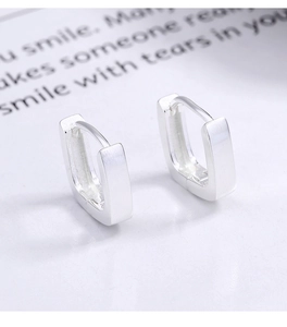 Macro shot of silver square geometric hoop earrings with a brushed matte metal finish