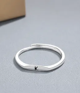 Macro shot of S925 sterling silver open ring featuring an engraved black letter K detail