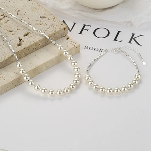 Set di gioielli in argento 925 con collana di perle e bracciale su sfondo di pietra