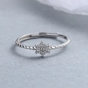 Macro detail of 925 silver daisy ring with sparkling zircons and braided band texture