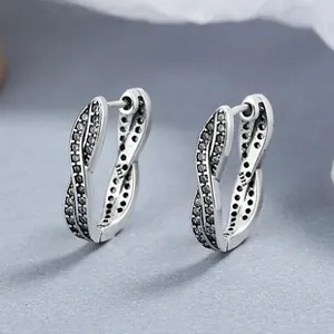Macro detail of S925 hallmark on twisted silver hoop earrings with black zircon pavé