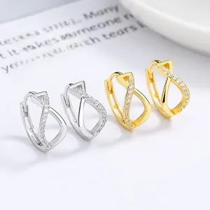 Close-up of twisted silver and gold hoop earrings with zircon micro-pave setting