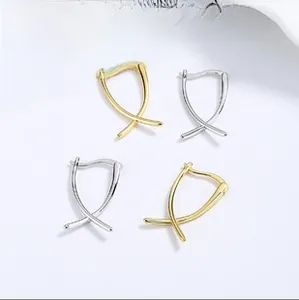 Detailed view of geometric X-shaped crossover earrings in gold and silver finish