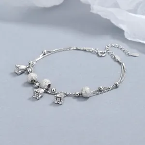 Détail macro du bracelet en argent sterling S925 avec pendentifs de muguet et perles