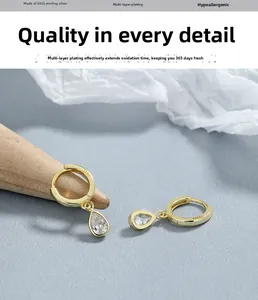 Gros plan détaillé de boucles d'oreilles huggie en argent 925 avec zircons en goutte d'eau