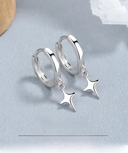 Macro shot of 925 sterling silver hoop earrings with polished four-pointed star charms