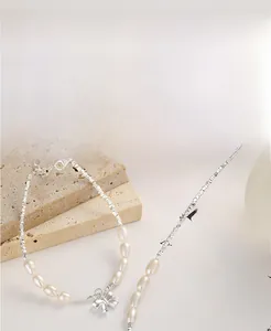 Detail of S925 sterling silver bow pendant and baroque pearls on an elegant chain